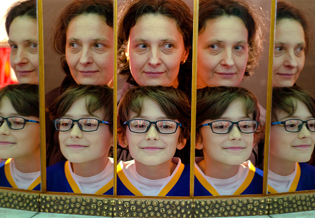 Boy and Woman's faces reflected in a mirror many times