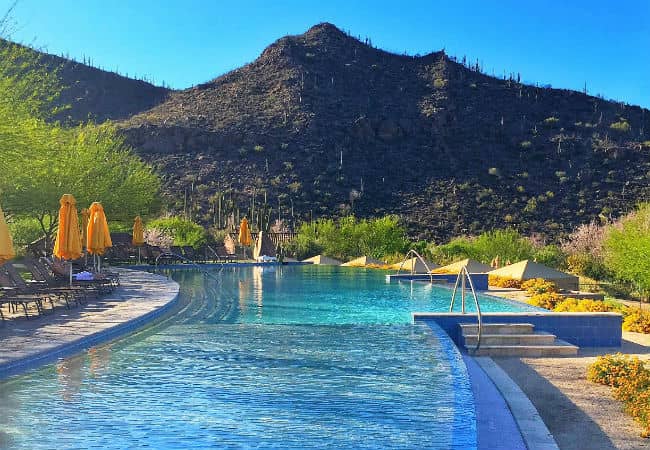 The pool at the Ritz-Carlton Dove Mountain in Marana, Arizona, with closed yellow umbrellas and lounge chairs surrounding the pool.