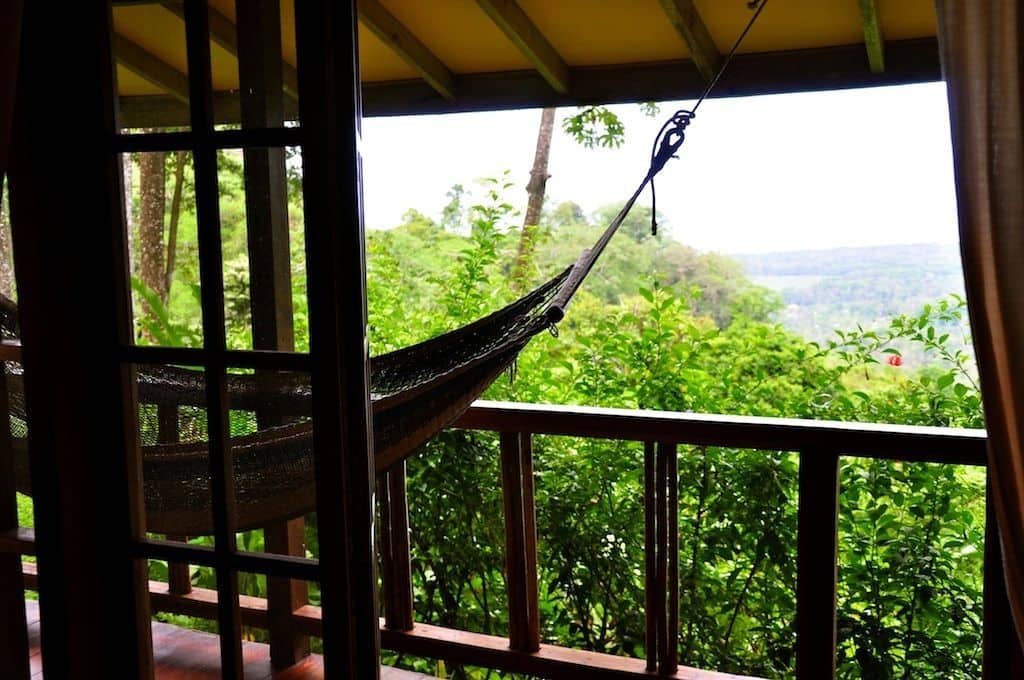 A hammock overlooking the Costa Rican jungle and nearby ocean from a private villa's balcony at the Samasati Yoga & Wellness Retreat.