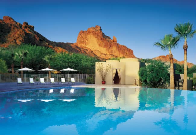 Camelback Mountain with a large crystal-clear infinity edge pool at the bottom of the mountain.