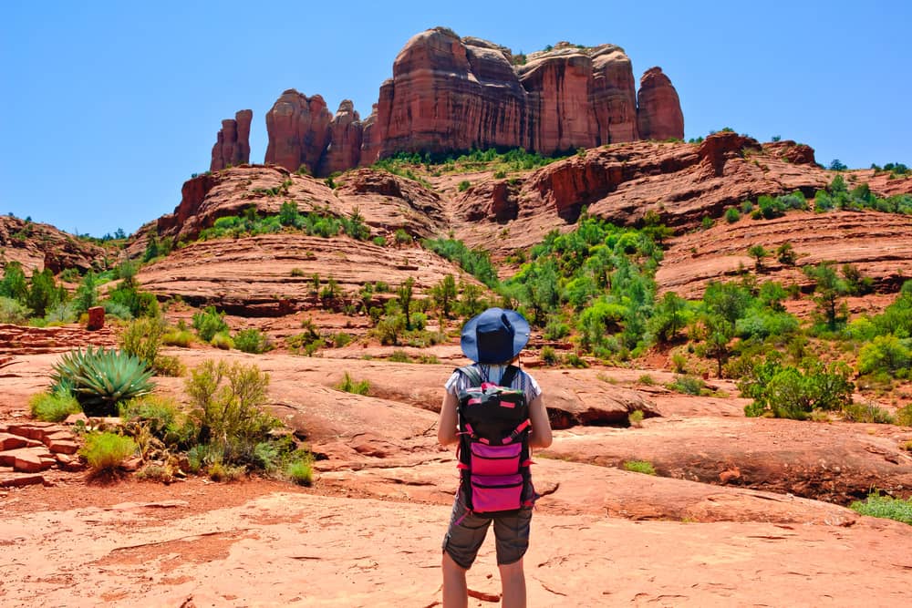 A female hiker facing away from the camera in Cathedral Rock located in Sedona Arizona
