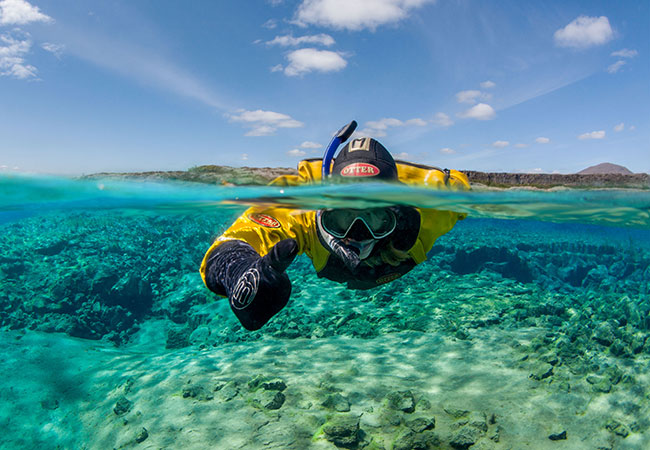 Snorkeler giving thumbs up at surface in clear waters in Reykjavik