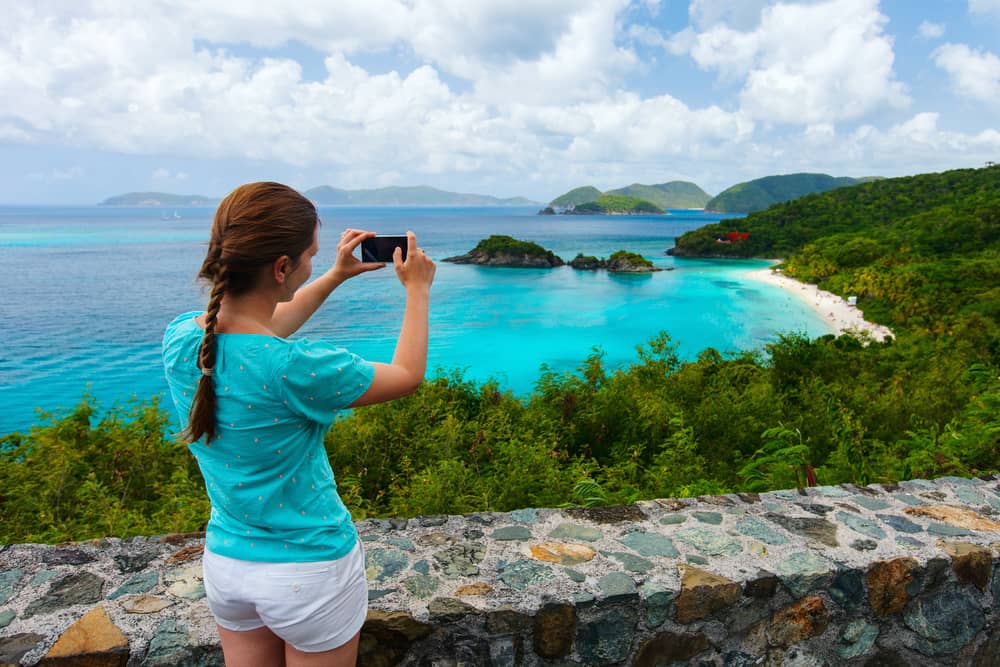 woman taking a photo of the beach and coastline of St John