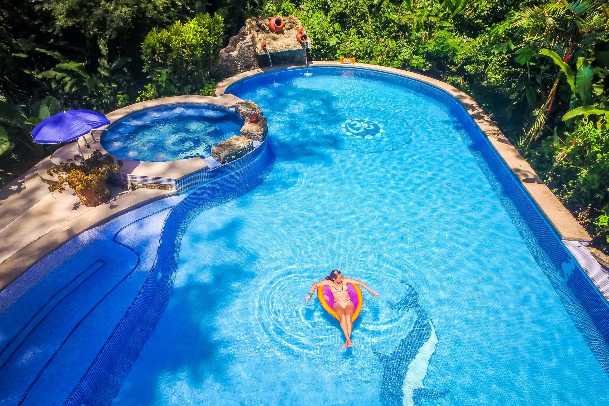 A woman in a bright blue pool at The Goddess Garden in Costa Rica.