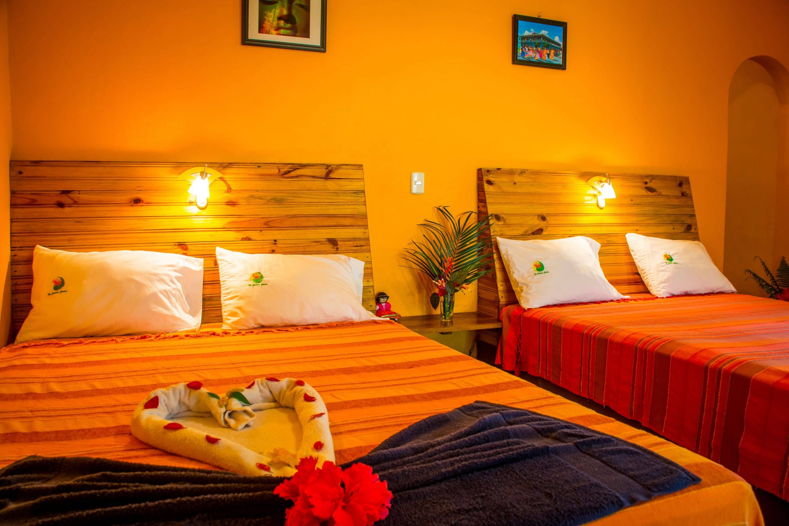 Bright bedding accompanies wooden features in this bright and rustic room at The Goddess Garden in Costa Rica.