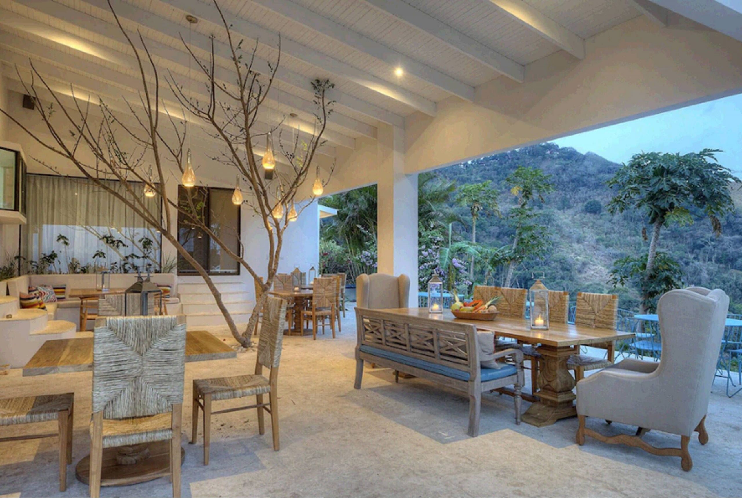 Then outdoor dining area for guests is designed with upscale furniture and beautiful wooden rustic chairs on an indoor-outdoor patio with beautiful views for as far as the eye can see.