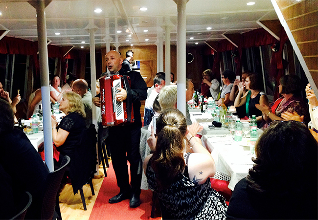 Man playing the accordion for guests on the Tiber River Evening Dinner Cruise in Rome