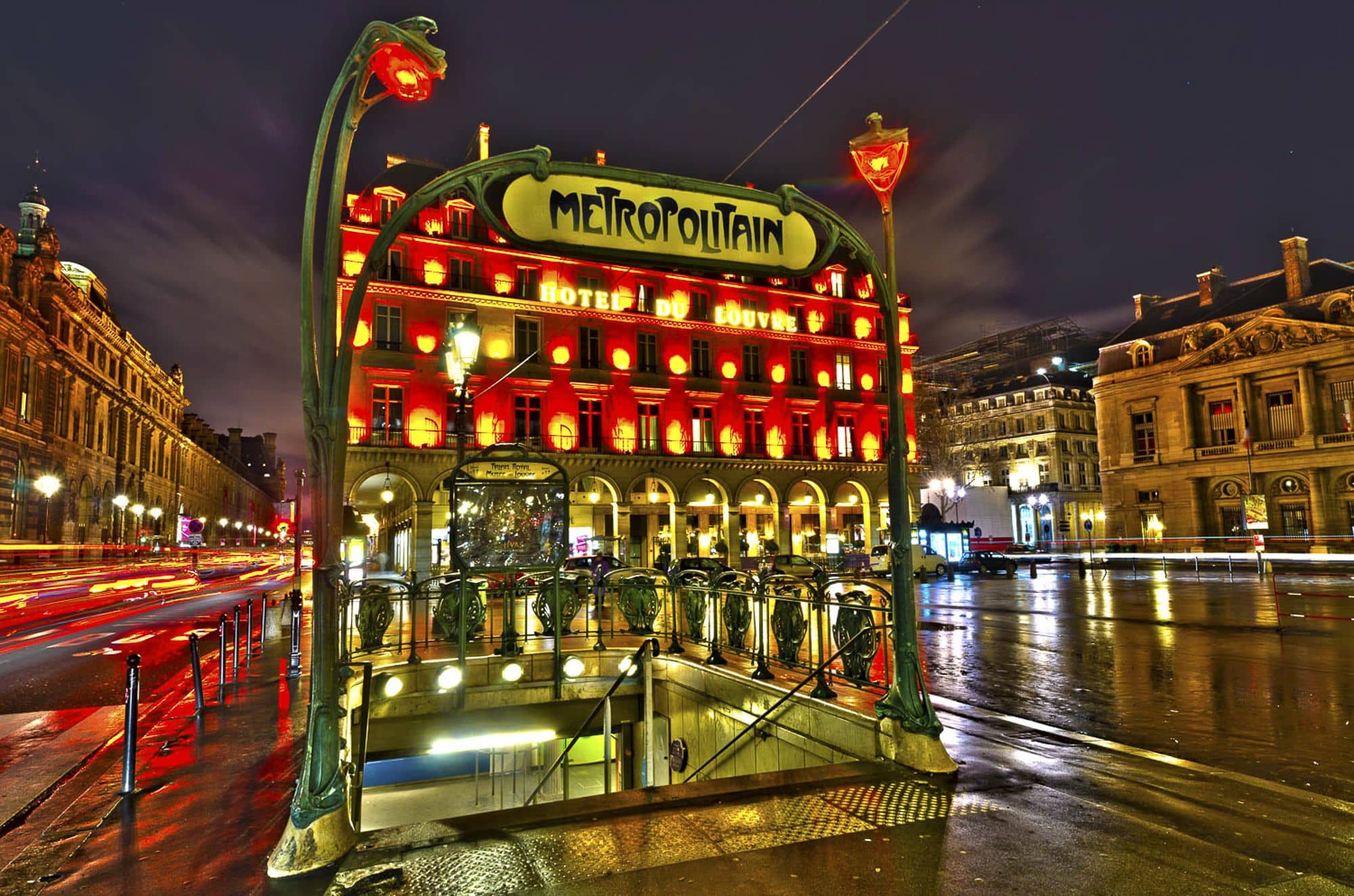 Wet Paris city streets lit up at night and the stairs down to the metro framed with glowing red lights