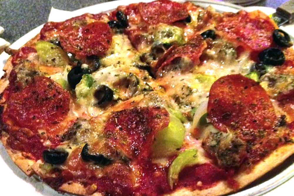 St. Louis-style pizza with Provel cheese, pepperoni, peppers, and olives on a thin crust.