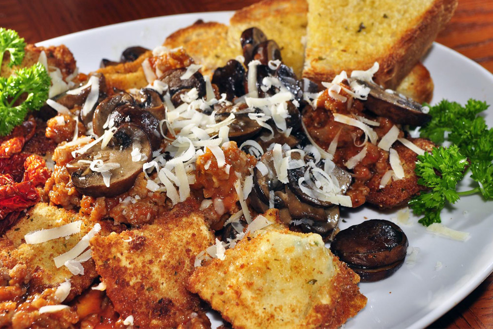 Toasted raviolis in meaty mushroom ragu with garlic bread—one of St. Louis's favorite foods