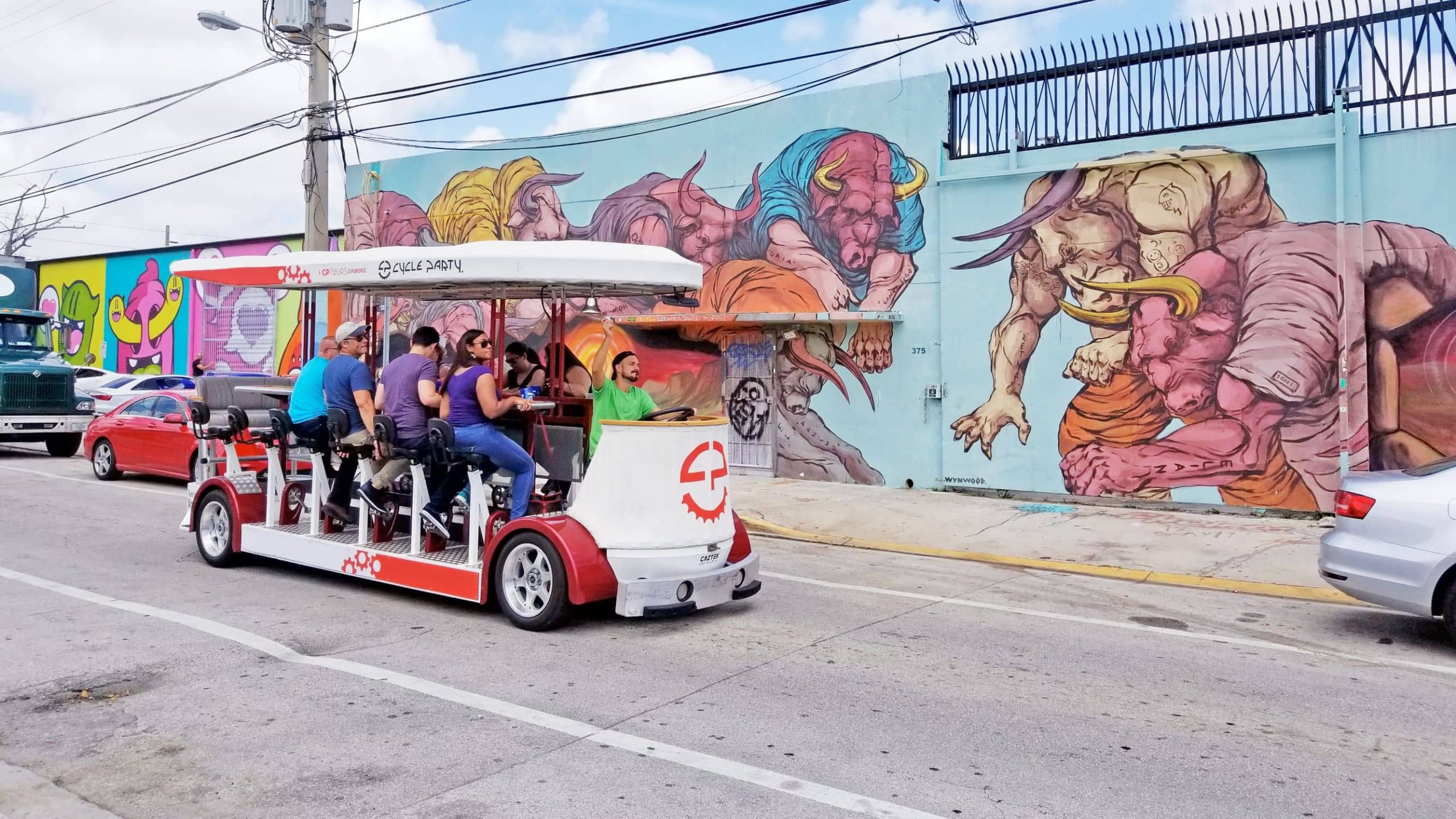 Friends pedal a party bike through the artsy Wynwood district.