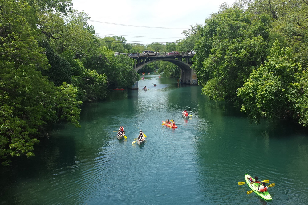 Kayaking along Lady Bird Lake, one of the best bachelor party ideas in Austin People kayaking in Lady Bird Lake, a top Austin bachelor party idea