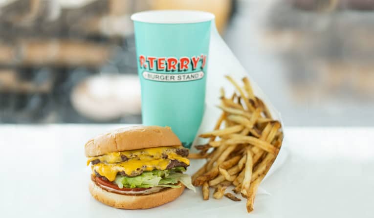 A double-patty cheeseburger, French fries, and a P. Terry's fountain drink.