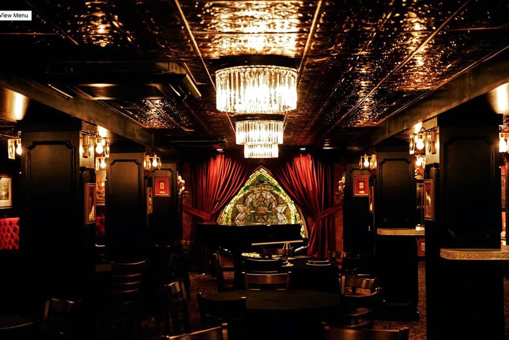 A corridor of tables and booths with chandeliers overhead in House of Cards, a historical bar under the Johnny Cash Museum