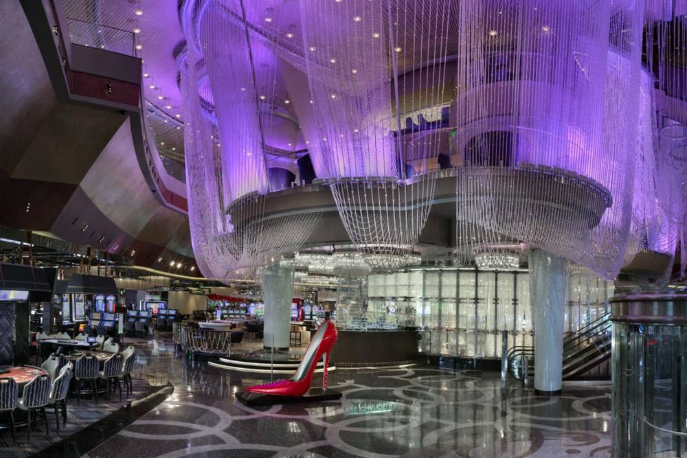 The draped curtains and big red shoe on the floor of The Chandelier, a perfect spot for a bachelorette party in Vegas.