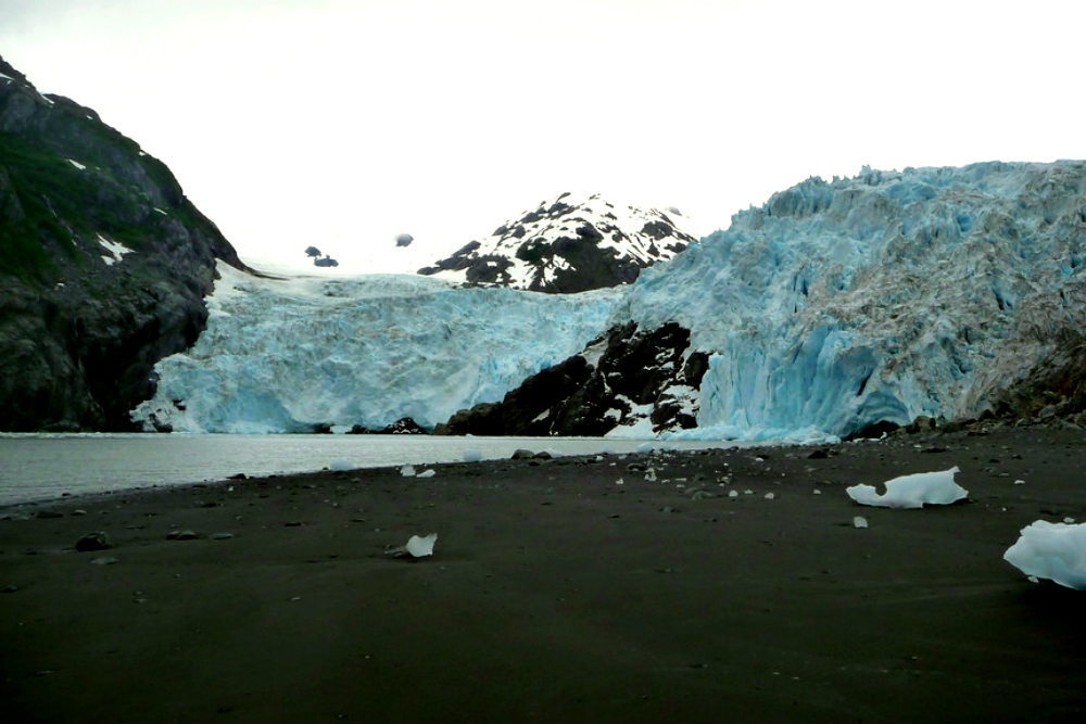 Black sand and blue iceberg chunks on the shores of Prince William Sound in Alaska. 