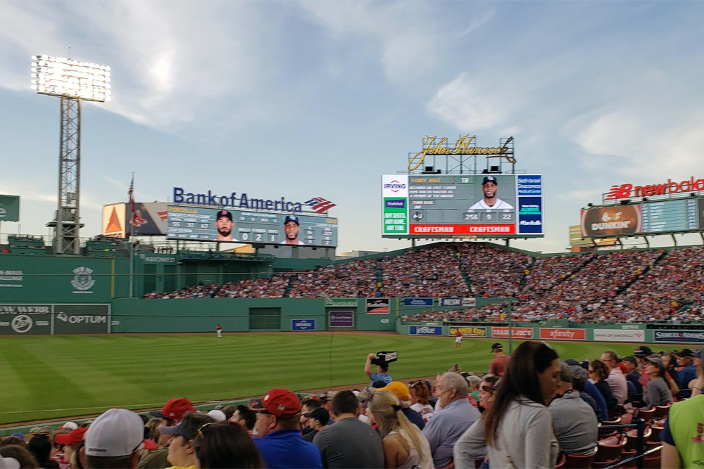 People cheering for the Red Sox at Fenway Park, a place Boston is know for. View of the field at Fenway Park, one of the things Boston is known for.