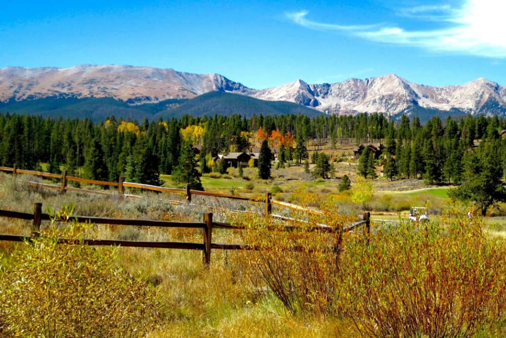 Rustic cabin surrounded by fall foliage with a mountain backdrop in Breckenridge, CO