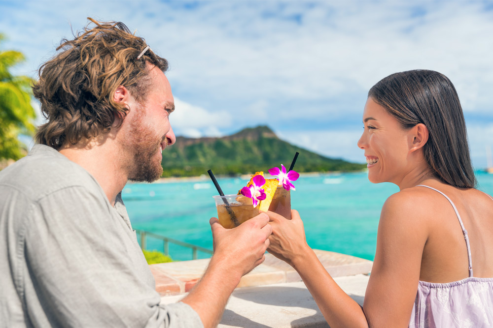 A couple cheers their fruity cocktails while enjoying cheap eats in Honolulu