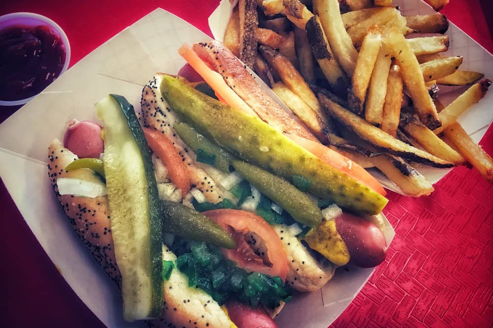 Eating a Chicago style hot dog is a must during the St. Patrick's Day Parade. Eating a Chicago style hot dog is a must-do activity during the St. Patrick's Day Parade in Chicago.