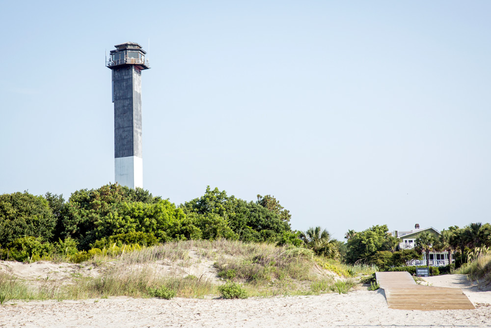 A lighthouse and boardwalk to the sand on Sullivan's Island in Charleston. It's a great date idea for special occasions.