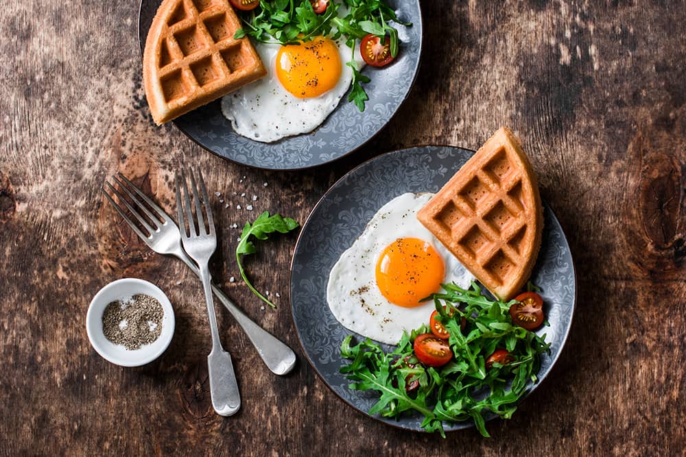 Breakfast plates of waffles eggs and salad - Chicago date ideas