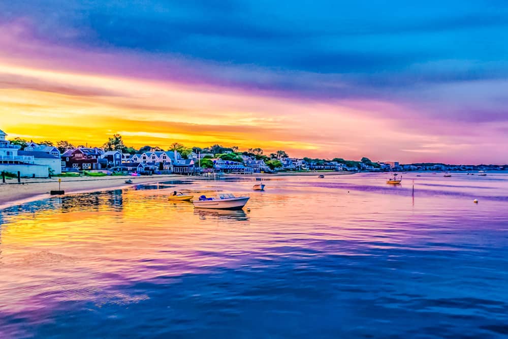 Sunset colors yellow, orange, and purple reflect off the water at sunset in Provincetown.
