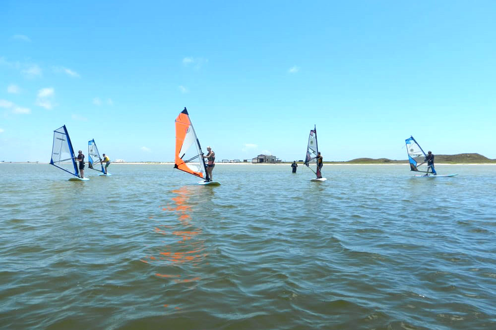 Group of windsurfers learning the sport on the calm waters off of Bird Island Basin.