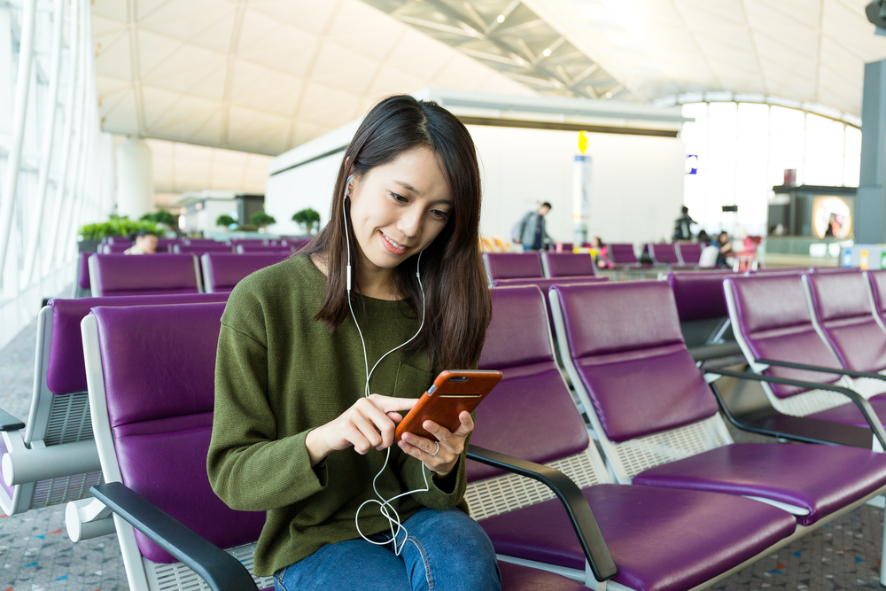 woman uses mobile travel app in an airport