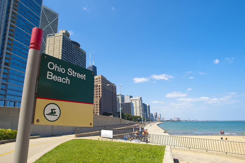 The sign for Ohio Street Beach overlooks the sandy strip, which is a prime free attraction to enjoy with kids in Chicago.