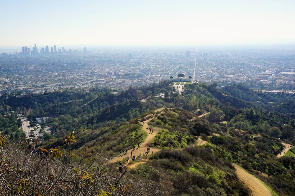 Griffith Park in the hills in northern Los Angeles with walking trails and hikers leading to the Griffith Park Observatory.