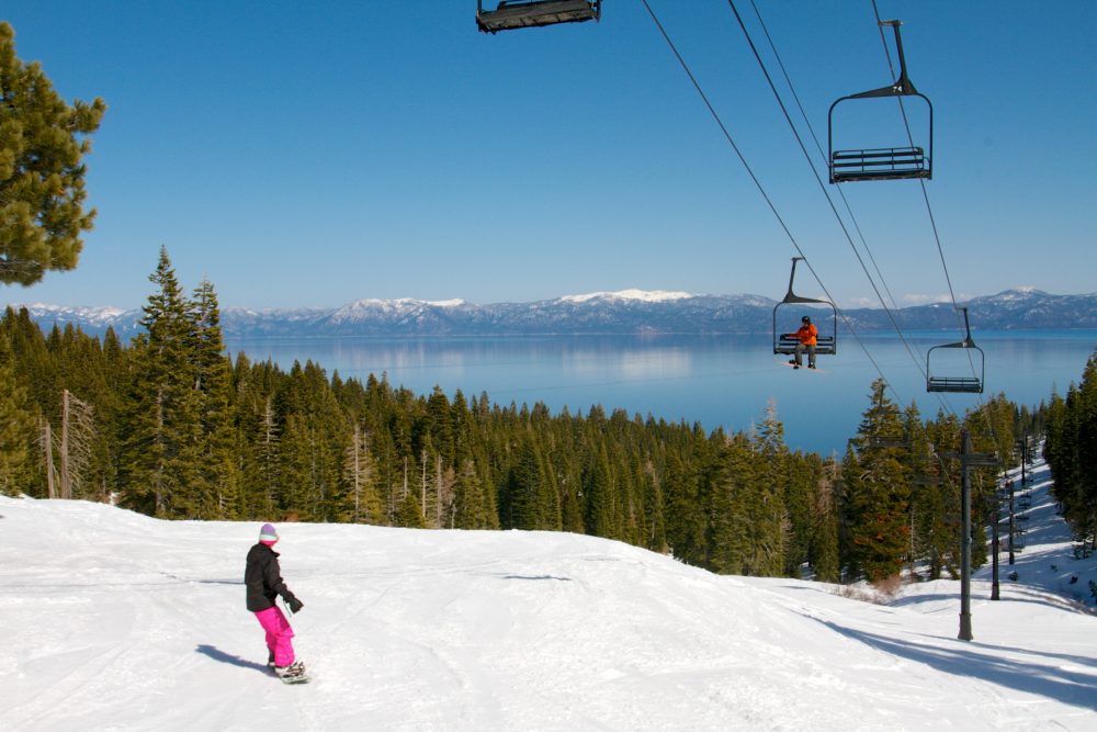View of a ski lift and snowy slopes overlooking Lake Tahoe