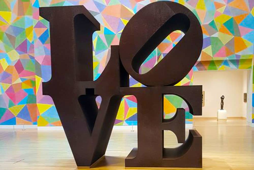 famous robert indiana LOVE sculpture in from of colorful wall in Newfields Museum, Indianapolis, Indiana