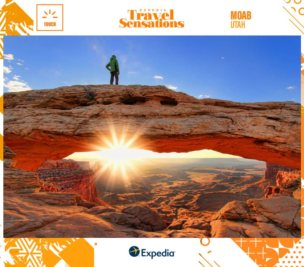 Silhouetted person standing on top of Mesa Arch, Canyonlands National Park, Utah