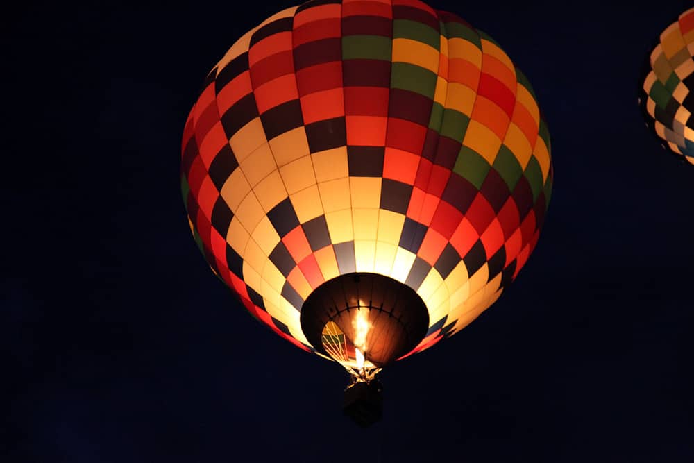 One hot air ballon is glowing in the dark night sky at the International Balloon Fiesta in Albuquerque.