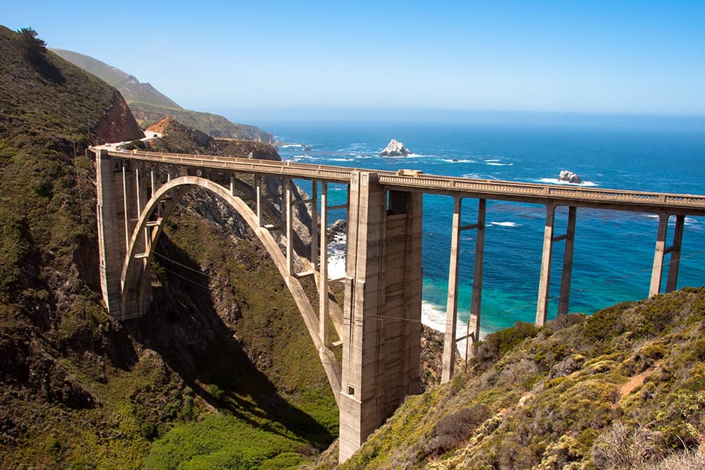 West-facing view of Bixby Bridge with bright blue ocean backdrop