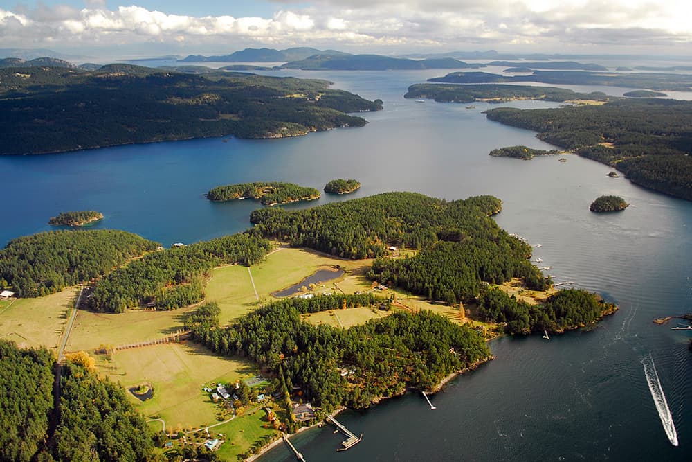 Aerial view of San Juan Islands with trees, clouds, and water