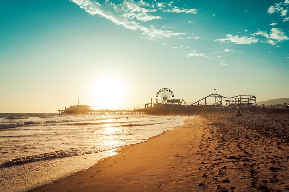 gold and blue sunset over the beach with Santa Monica Pier in the distance