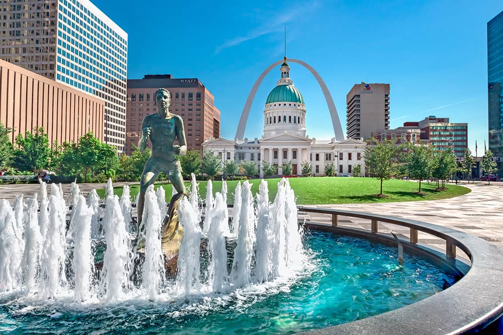 view of Kiener Plaza in St. Louis, MO on a sunny day with the Gateway Arch in background