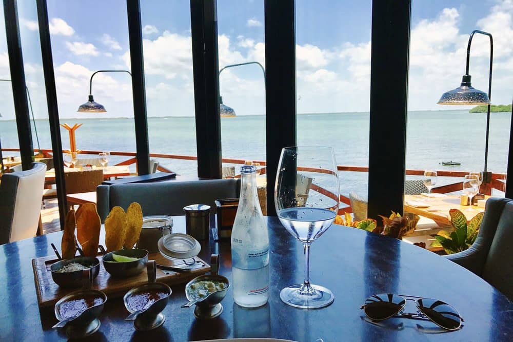 Dining table set with glassware and gourmet salsas with an ocean view in Cancun