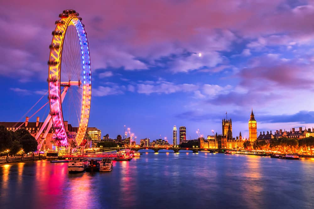 Nightime view of the London Eye Ferris—seeing this attraction is a great London travel tip. View of the London Eye Ferris wheel at night—seeing this attraction is a great London travel tip.