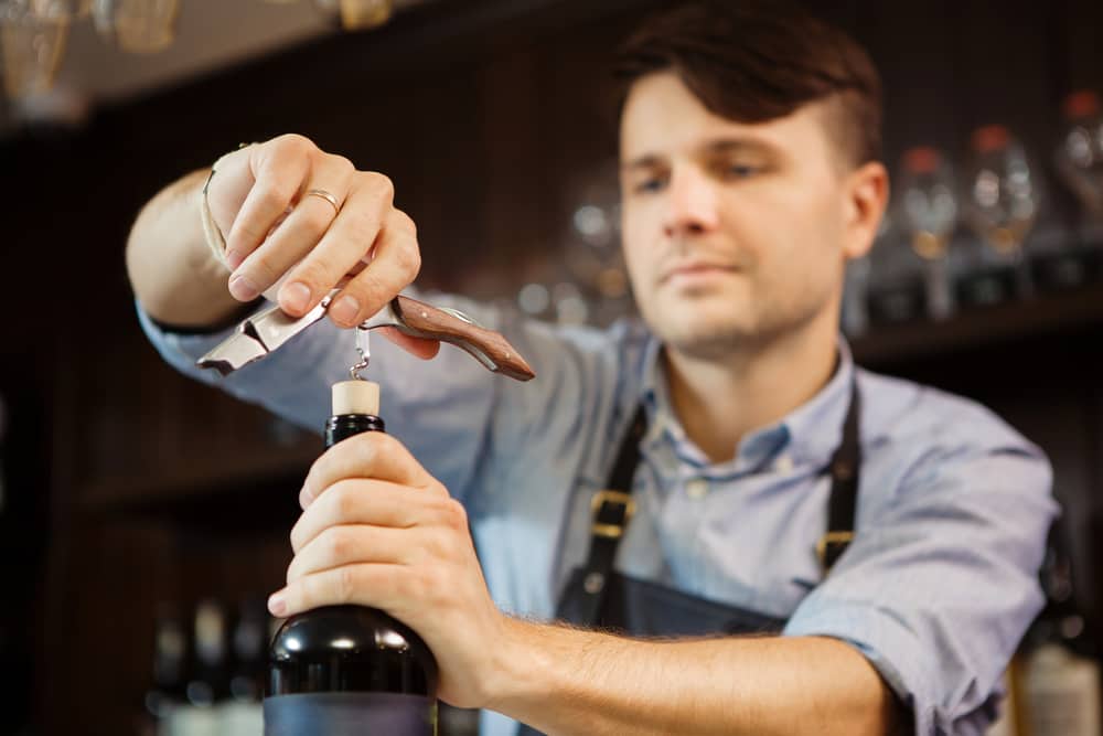 Man opening bottle of wine to serve for wine tasting