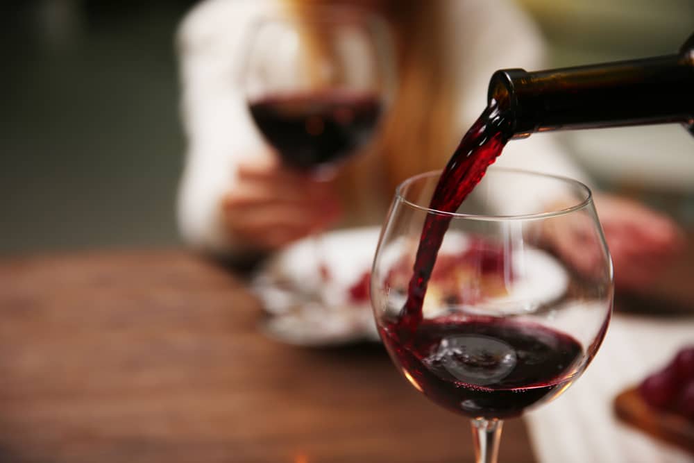 Red wine poured into wine glass for wine tasting